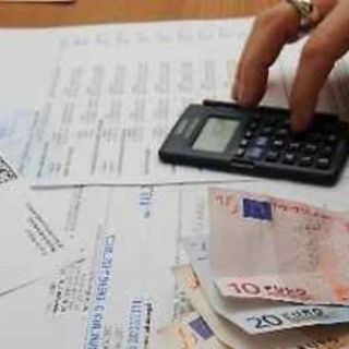 persona che fa calcoli con delle bollette sul tavolo