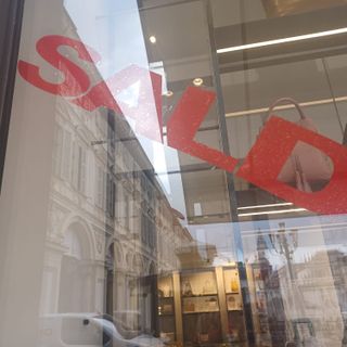 Vetrina con la scritta "Saldi" in diagonale e in rosso