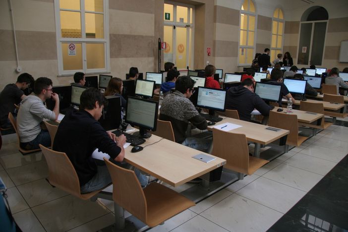Studenti davanti ai computer tra i banchi di scuola