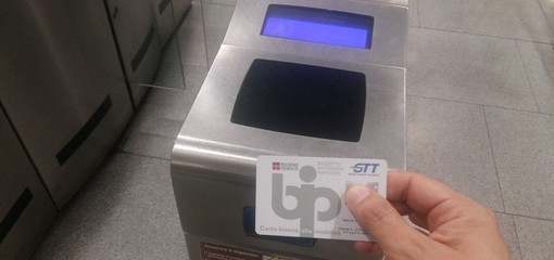 mano mostra abbonamento gtt bip card davanti all'ingresso della metro