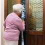 Donna anziana apre la porta